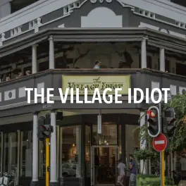 The Village Idiot pub exterior with entrance beneath balcony