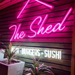 The Shed neon sign advertising burgers and sushi