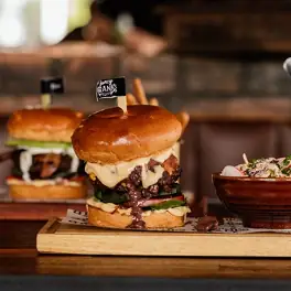 Gourmet cheeseburger with melted cheese and toasted bun on wooden board