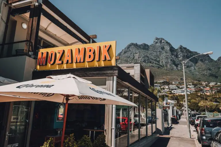Mozambik restaurant sign and outdoor seating with mountain backdrop