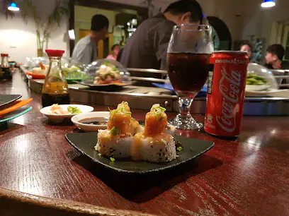 Sushi rolls on black plate with glass of cola and Coca-Cola can