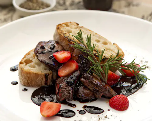 Toasted bread with braised meat, balsamic glaze, strawberries and rosemary