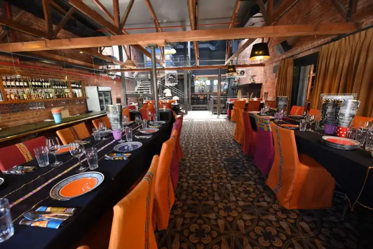 GOLD Restaurant dining room with long tables set for African dinner